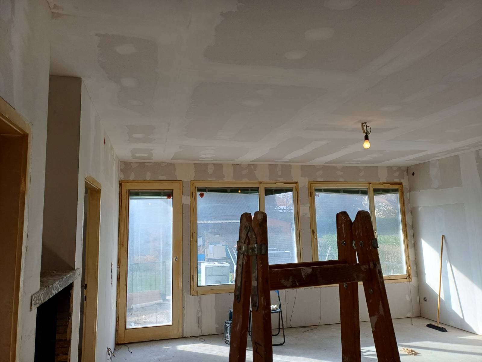 Wohnzimmer während der Sanierung – gespachtelte Decke und alte Holzfenster