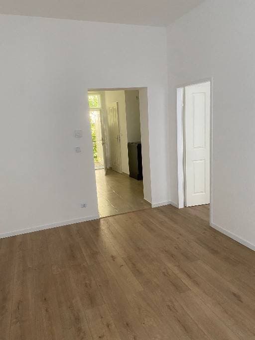 Fertiggestelltes Zimmer mit neuem Laminatboden und weißen Innentüren